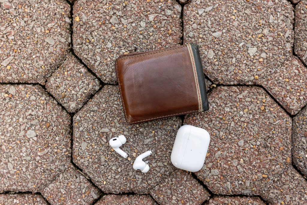 Photo of a wallet and airpods lying on the ground.